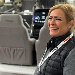 Wicmarinen myymäläpäällikkö Victoria Berg istuu nauravaisena Yamarinin kyydissä messuhallissa.
