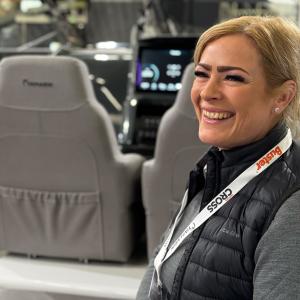 Wicmarinen myymäläpäällikkö Victoria Berg istuu nauravaisena Yamarinin kyydissä messuhallissa.